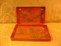 Two Chinese orange lacquer rectangular trays painted in gilt with Chinese landscapes