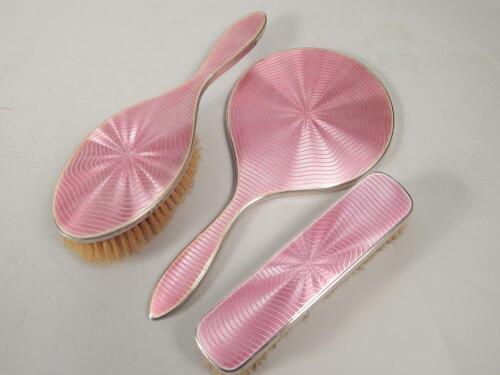 An Art Deco silver and pink guilloche enamel part dressing table set