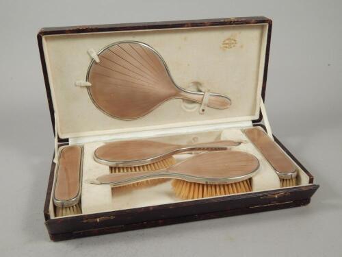 A George V Art Deco style silver and gold guilloche enamel dressing table set