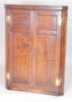 A late 18thC panelled oak corner cupboard