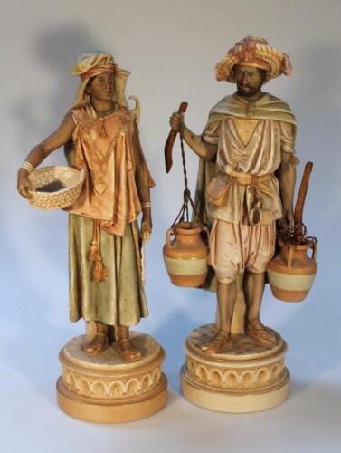 A pair of Royal Dux figures of Arabian water carriers