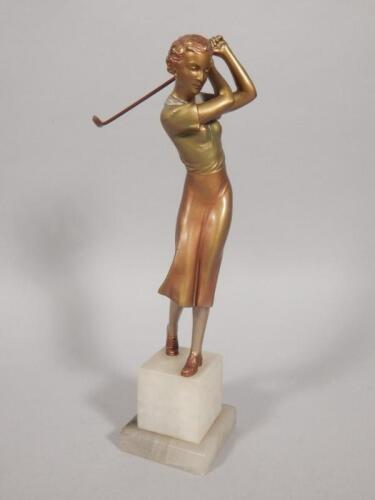 An Art Deco cold painted figure of a female golfer