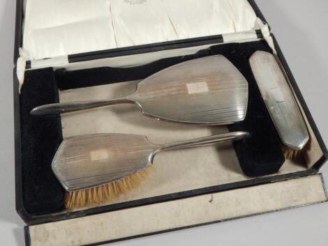 A silver Art Deco style three piece dressing table set