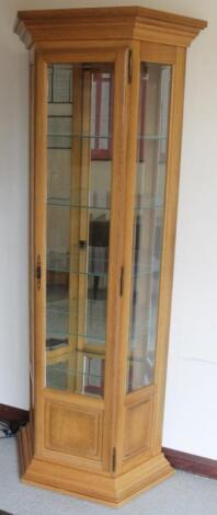 A modern light oak finish glazed display cabinet