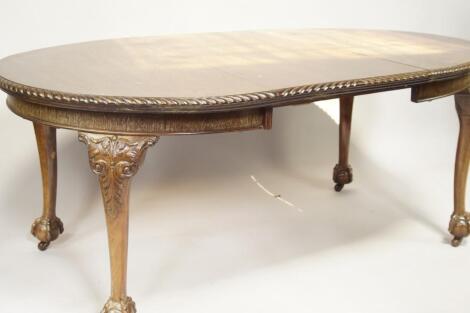 An early 20thC Chippendale Revival mahogany extending wind-out dining table