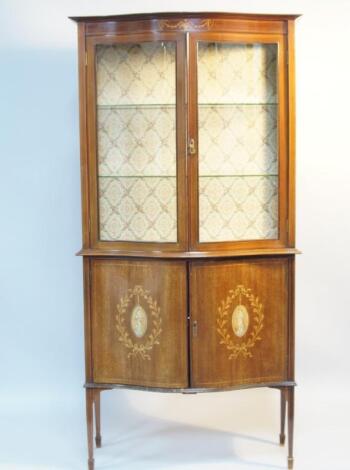 An Edwardian mahogany and marquetry serpentine fronted display cabinet