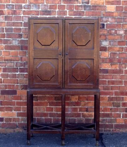 An early 20thC oak cabinet on stand