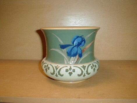 A Langleyware pottery jardiniere painted with iris against a deep blue/green ground