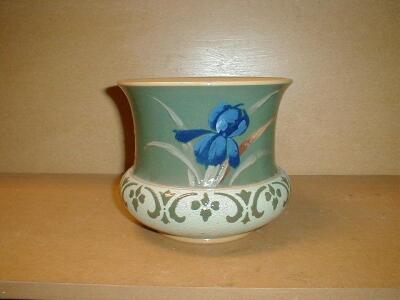 A Langleyware pottery jardiniere painted with iris against a deep blue/green ground