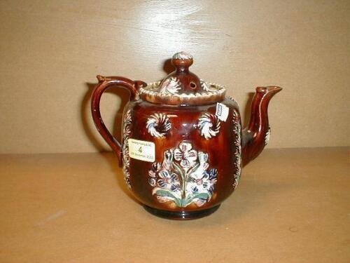 A Bargeware teapot moulded in relief with flowers and bearing incised