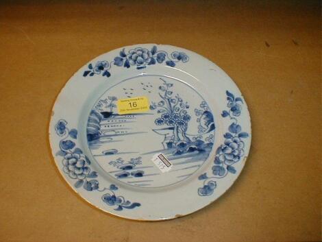 An 18thC Delf plate, painted with a landscape within single line border,