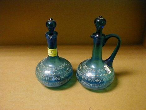 A pair of 19thC blue glass ewers with teardrop stoppers