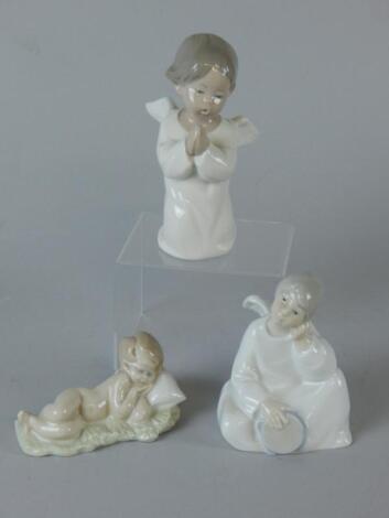 A Lladro figure group of a praying angel