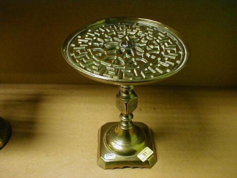 A cast brass trivet with a circular pierced top