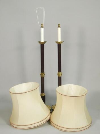 A pair of brass and bronzed candlestick type floor lamps