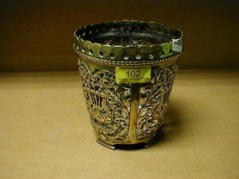 A cast brass planter, pierced with panels of foliage issuing from urns,