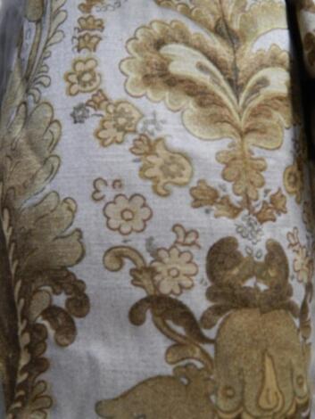 A pair of full length silver and gold patterned curtains