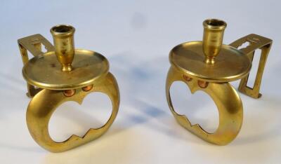 A pair of brass fire dog candlesticks