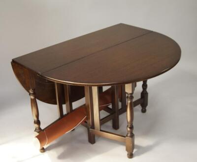 A reproduction oak gateleg table and six ladderback chairs.