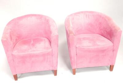 A pair of fuchsia suede effect tub chairs.