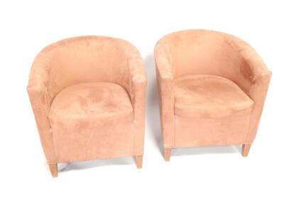 A pair of brown suede effect tub chairs.