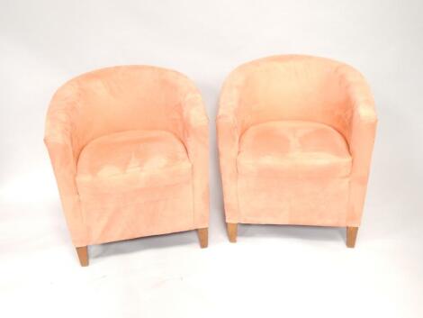 A pair of salmon suede effect tub chairs.