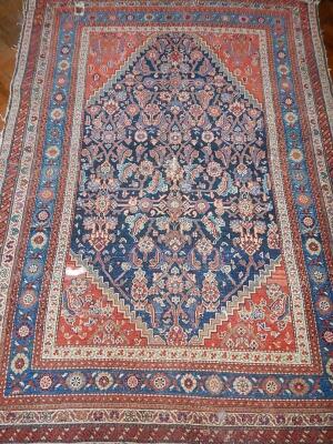 A 19thC Persian bordered rug in blue and red