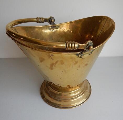 A brass tapered coal bucket with swing handle.