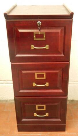 A reproduction stained oak filing cabinet