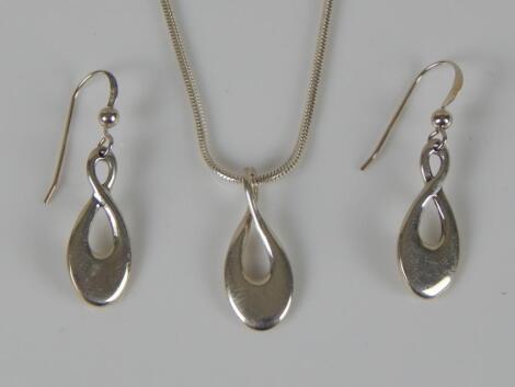 A modern silver pendant and earring set