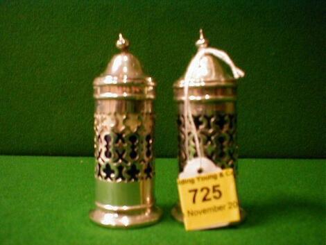 A pair of Edwardian silver openwork cylindrical pepperettes