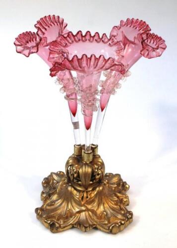 An early 20thC cranberry and clear glass three branch epergne