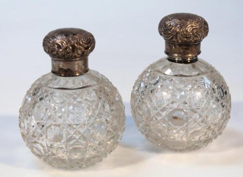 A pair of early 20thC cut glass and silver dressing table jars