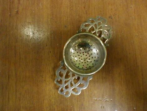 A silver tea strainer