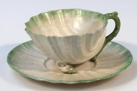 An early 20thC Belleek shell shaped cup and saucer