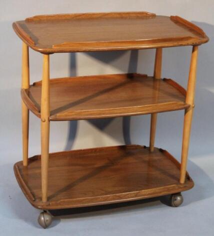 A 20thC Ercol light wood three tier dining room trolley