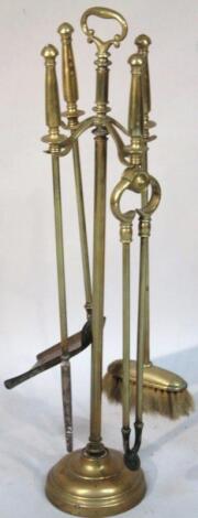 An early 20thC brass fireside companion set