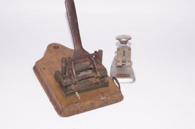 An early 20thC oak mounted hole punch