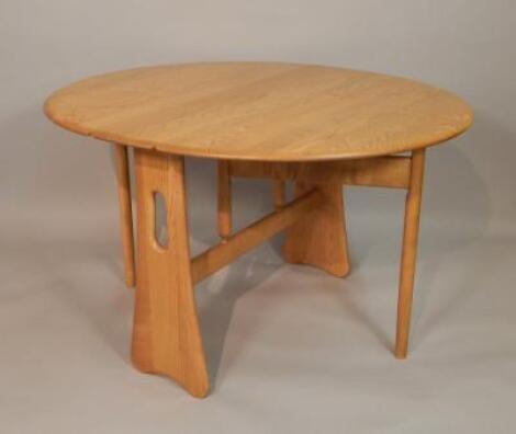 A modern light elm Ercol oval drop leaf table