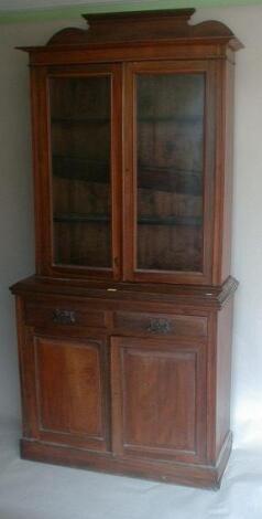 A late Victorian walnut cabinet bookcase with two door glazed top over