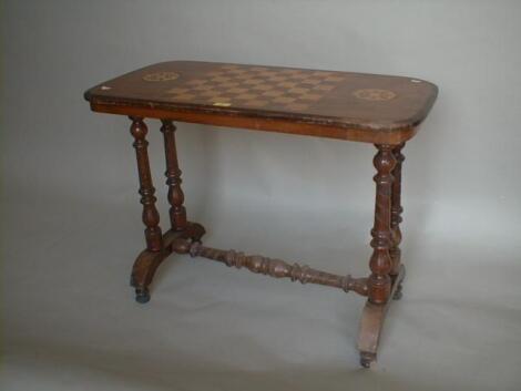 A Victorian walnut centre table with marquetry and games board inlaid top