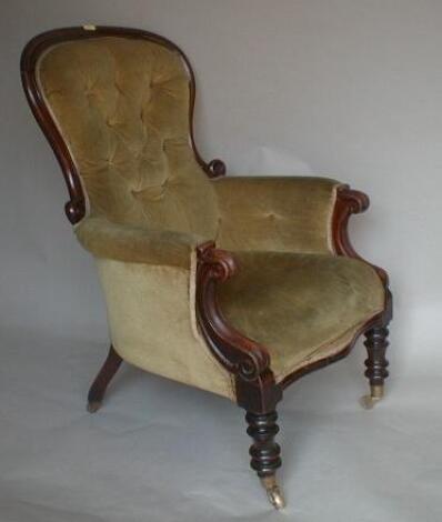 A Victorian mahogany spoonback armchair with scroll arms