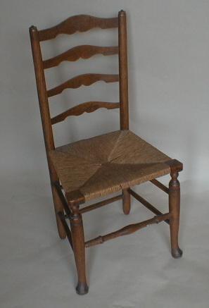 Three early 19thC oak ladder back chairs with rush seats