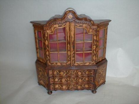 A Dutch style floral marquetry miniature cabinet of bombe form with glazed