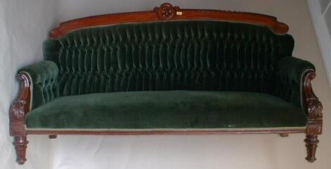 A Victorian mahogany sofa with gadrooned and scrolling frame raised on