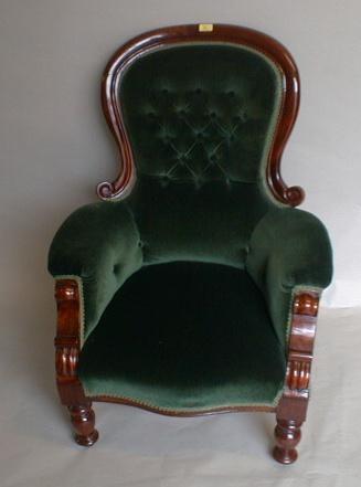 A Victorian mahogany spoonback armchair with carved serpentine frame and