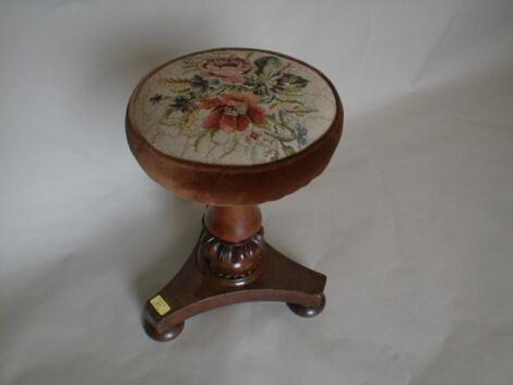 A Victorian mahogany piano stool with circular woolwork rise and fall seat