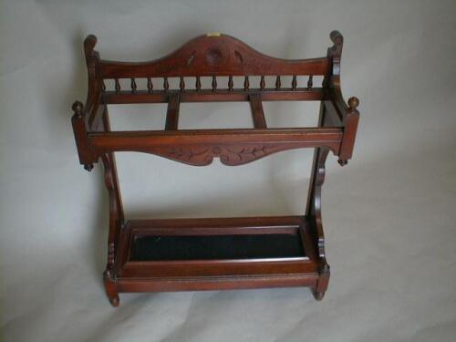 A late Victorian walnut stick stand with stratch carved and galleried back