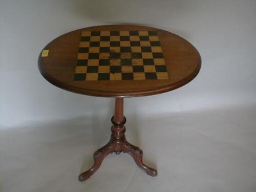 A Victorian mahogany games table with moulded oval top inset with a chequer board