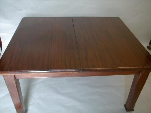 An Edwardian mahogany extending dining table with two extension leaves